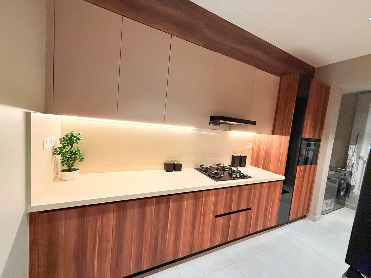 Delivered parallel kitchen in walnut and champagne finishes with lit quartz backsplash