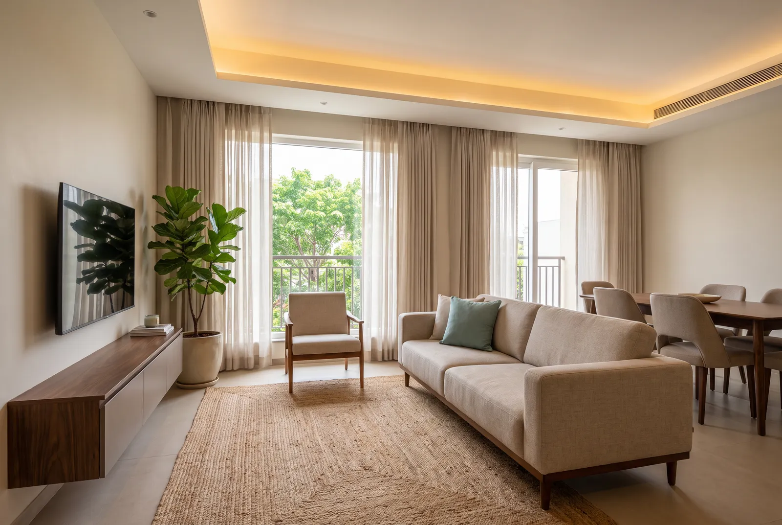 Warm minimal open-plan living and dining room in a Bengaluru apartment