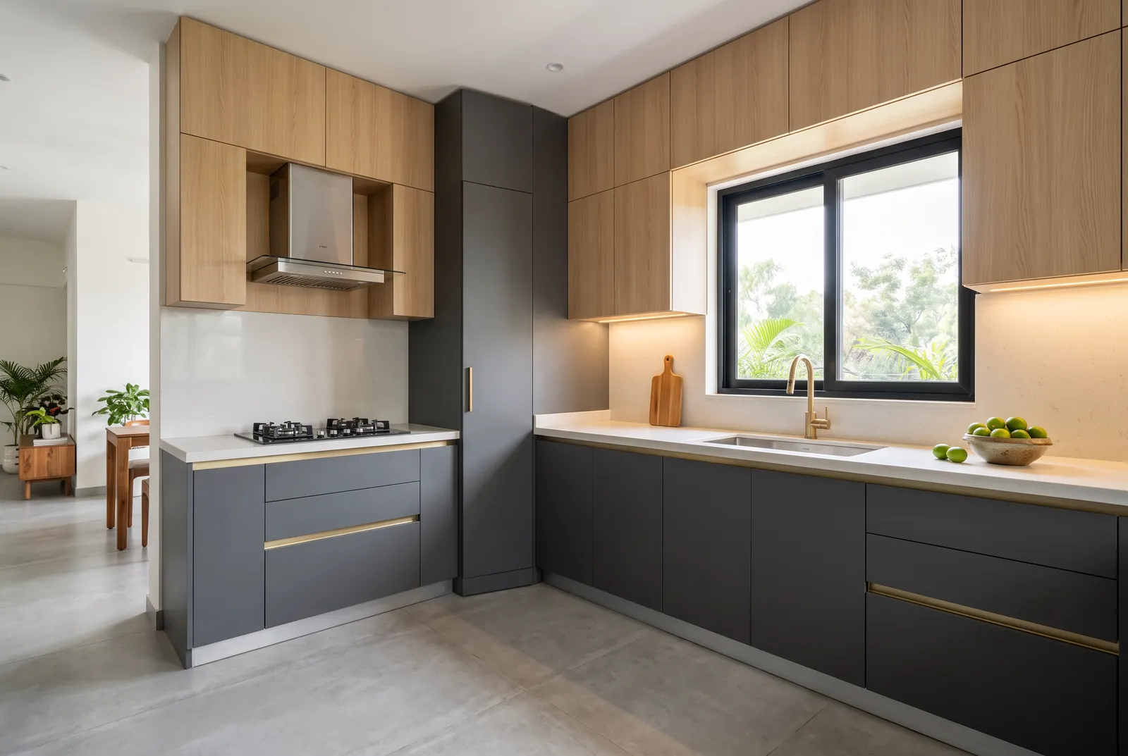 L-shaped modular kitchen with a stainless steel chimney over the hob and a quartz countertop